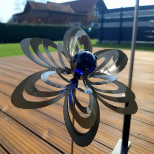 Künstlerisches Metallkunstwerk in Form einer Blumen mit blauer Kristallkugel, ideales Deko-Objekt im Garten.