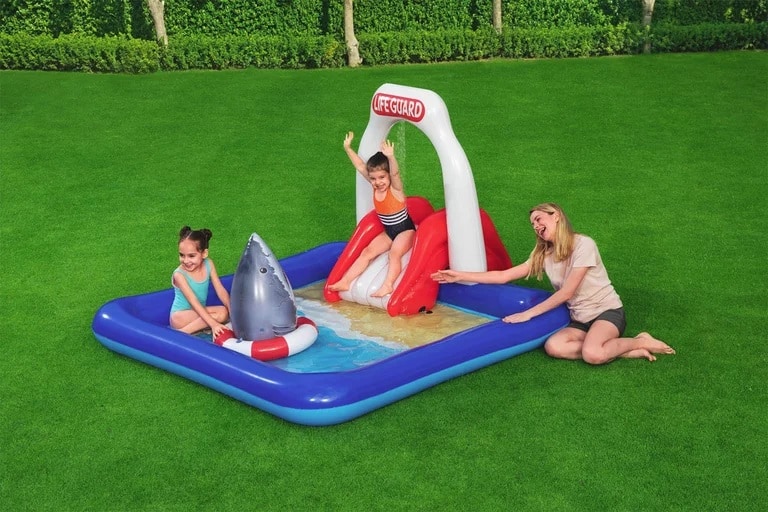 Bunte aufblasbare Wasserlage mit Wasser spritzer und Rutsche, ideal für Kinder im Garten.