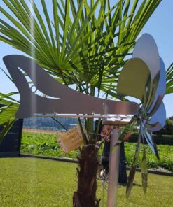 Alt-Text: Metall-Windspiel an einer Palme im Garten, reflektierend und dekorativ.