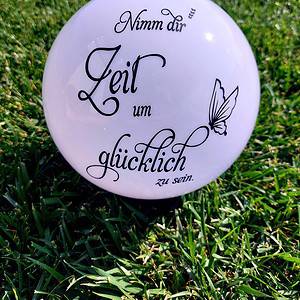 Auf diesem weißen, dekorativen Ball befindet sich der inspirierende Spruch