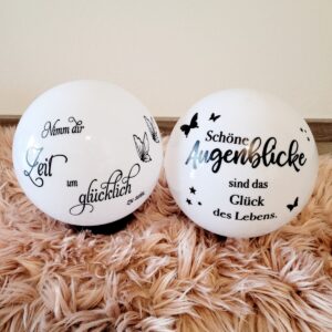 Helle Ballons mit positiven Zitaten und Schmetterlingen auf flauschigem Teppich für besondere Anlässe.